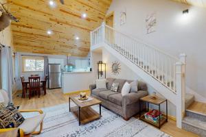 a living room with a couch and a staircase at Chalet on the Bay in Saint Germain