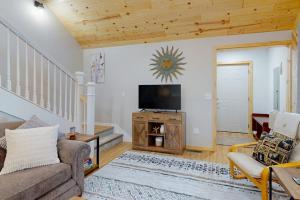 a living room with a couch and a tv at Chalet on the Bay in Saint Germain +30 photos