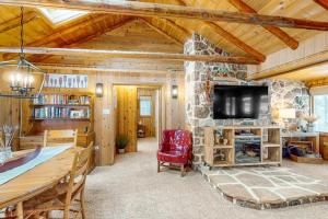 a living room with a stone fireplace and a tv at Stormy Point Cabin in Conover