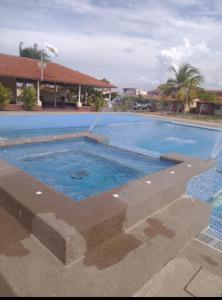 a large swimming pool with blue water at Conjunto Costa Grande villas in Higuerote