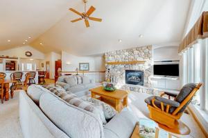 a living room with couches and a stone fireplace at Yellow Birch Memories in Eagle River