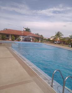 a large swimming pool with blue water at Conjunto Costa Grande villas in Higuerote