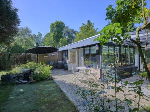 a garden with an umbrella and a house at Bungalow Sonnerust in Lanaken