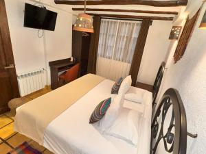 a bedroom with a bed with a chair and a television at Vilas Insight Hotel Machupicchu in Machu Picchu