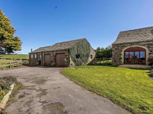 an old stone barn with a driveway in front of it at 2 Bed in Holmfirth oc-emley in New Mills