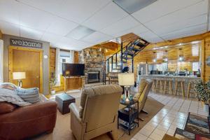 a living room with a couch and chairs and a kitchen at Roaming Deer Cottage in Saint Germain