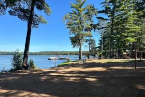 a park next to a lake with a boat in the water at Roaming Deer Cottage in Saint Germain