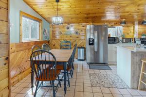 a kitchen with a table and chairs and a refrigerator at Roaming Deer Cottage in Saint Germain