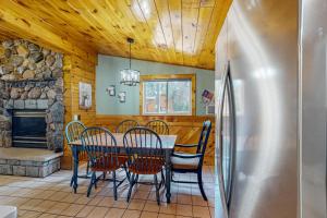 a dining room with a table and chairs and a refrigerator at Roaming Deer Cottage in Saint Germain +27 photos