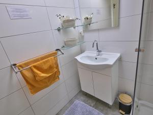 a white bathroom with a sink and a mirror at Bungalow Sonnerust in Lanaken +32 photos