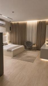 a bedroom with a bed and a chair and a table at Modern Studio Near Al Haram And City Center Self Check-in in Medina