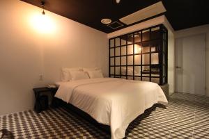 釜山的住宿－SOYU酒店，卧室配有白色的床和窗户。