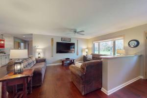 a living room with two couches and a tv at The 19th Hole Lakeside in Eagle River