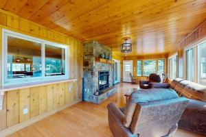 a living room with a couch and a stone fireplace at The 19th Hole Lakeside in Eagle River
