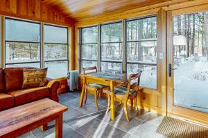 ein Wohnzimmer mit einem Tisch, einer Couch und Fenstern in der Unterkunft Seasons Pass in Eagle River