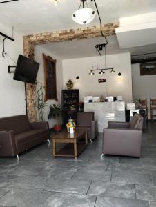a living room with couches and a tv and a table at Hotel CHOLOA in Cholula