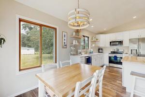 a kitchen with a wooden table and white cabinets at Rome Retreat- Steps from Beach & Golf in Nekoosa