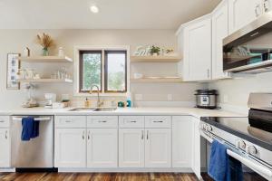 a white kitchen with white cabinets and a sink at Rome Retreat- Steps from Beach & Golf in Nekoosa