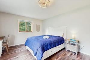 a bedroom with a bed with a blue comforter at Rome Retreat- Steps from Beach & Golf in Nekoosa +21 photos