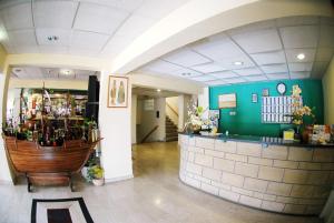 a room with a bar and a green wall at Cornelia Hotel in Ayia Napa