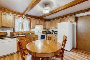 a kitchen with a wooden table and a white refrigerator at Rustic Woodland Retreat- Unit A in Arkdale