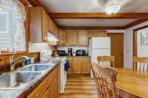 a kitchen with wooden cabinets and a white refrigerator at Rustic Woodland Retreat- Unit A in Arkdale +6 photos