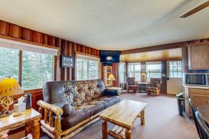 a living room with a leather couch and a table at The View on Found Lake in Saint Germain