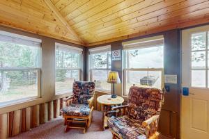 a room with two chairs and a table and windows at The View on Found Lake in Saint Germain