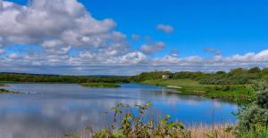 a view of a lake with a house in the distance at 2 Bed in Morpeth oc-36925 in Widdrington +7 photos
