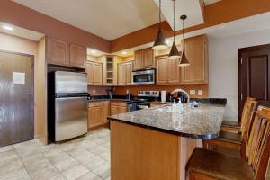 a kitchen with wooden cabinets and a stainless steel refrigerator at Chula Vista Resort 2224 & 2226 in Wisconsin Dells +30 photos