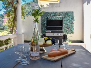 a table with a bottle of wine and wine glasses at Paulette in Éze