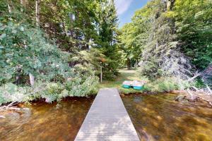 a wooden bridge over a river with trees at Flagpole Point in Phelps