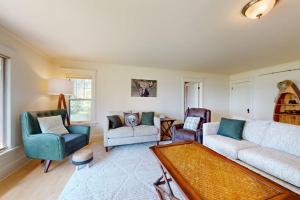 a living room with a couch and chairs and a table at Flagpole Point in Phelps
