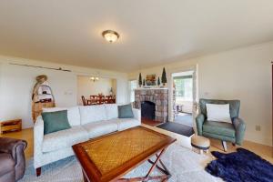 a living room with a couch and chairs and a fireplace at Flagpole Point in Phelps