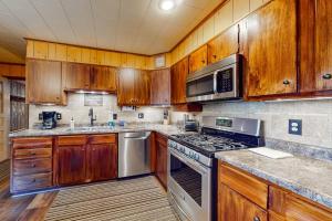a kitchen with wooden cabinets and stainless steel appliances at Konkey's Kabin in Saint Germain +35 photos