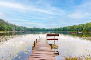a bench sitting on a dock on a lake at Hillis House in Arbor Vitae