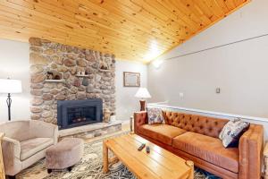 a living room with a couch and a stone fireplace at Hillis House in Arbor Vitae