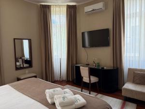 a hotel room with a bed and a desk and a television at Hotel Victoria Plaza in Tarija