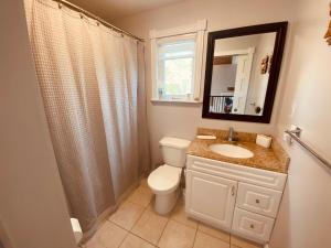 a bathroom with a toilet and a sink and a mirror at 5 bedroom Waterfront house in Tracadie +11 photos