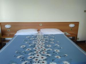 ein Bett mit einer blauen Decke mit Blumen drauf in der Unterkunft Albergo Bandoni in Rapallo