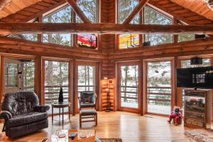 a living room with a large wooden ceiling with windows at Sailor's Point Lodge in Eagle River