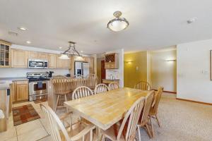 a kitchen and dining room with a wooden table and chairs at Sunset Condominiums: Golf View in Arkdale +26 photos