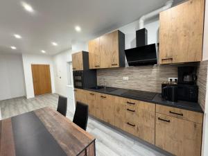 a kitchen with wooden cabinets and a wooden table and a dining room at Sachsenheim Rooms & Apartments in Sachsenheim