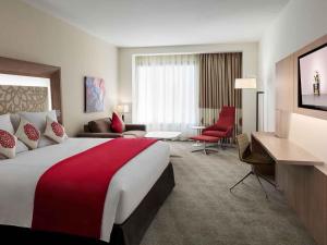 a hotel room with a large bed and a living room at Novotel Jeddah Tahlia in Jeddah