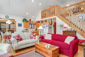 a living room with a red couch and a table at RTLCMP Lakehouse in Arbor Vitae