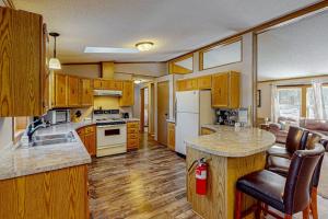 a kitchen with wooden cabinets and a white refrigerator at Thoro Cottage in Minocqua