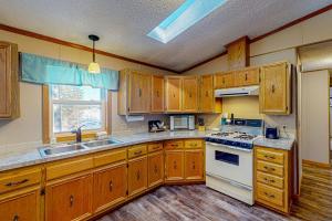 a kitchen with wooden cabinets and a white stove top oven at Thoro Cottage in Minocqua +12 photos
