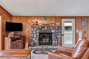 ein Wohnzimmer mit einem Steinkamin und einem Fernseher in der Unterkunft Equanimity in Eagle River