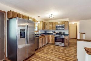 eine Küche mit Edelstahlkühlschrank und Holzschränken in der Unterkunft Mitchell Point Cottage in Eagle River + 15 Fotos