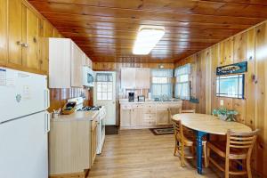 a kitchen with a table and a white refrigerator at Chickadee Cabin in Saint Germain